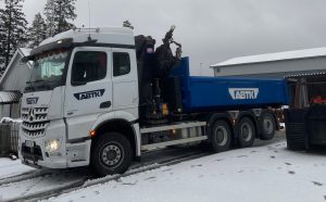 vit lastbil i snö kör blått släp